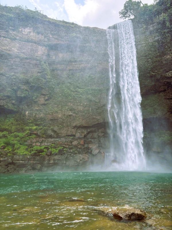 Scenic view of Phe Phe Waterfall surrounded by lush green cliffs in Meghalaya.