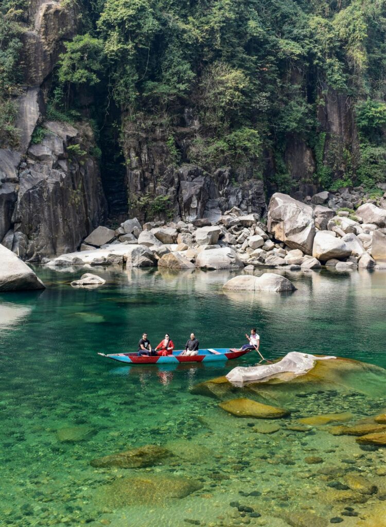 travelers kayaking on Umngot River at golden hour near Dawki