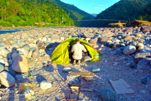 person preparing tent for the river camping in shnongpdeng